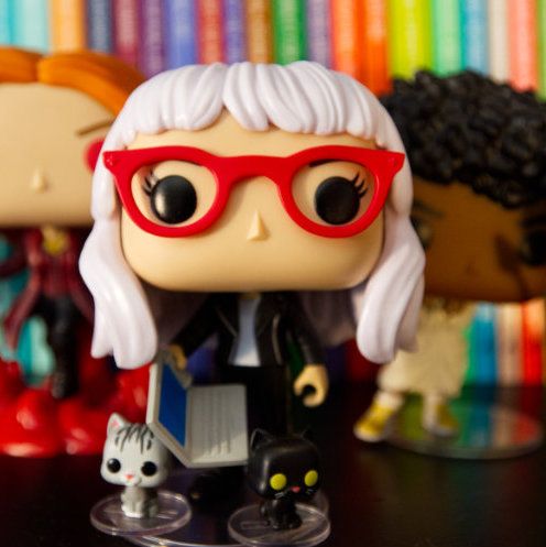 Me as a Funko Pop wearing a motorcycle jacket, holding a laptop and accompanied by tiny funko kittens that represent Anakin and Kubrick, my cats